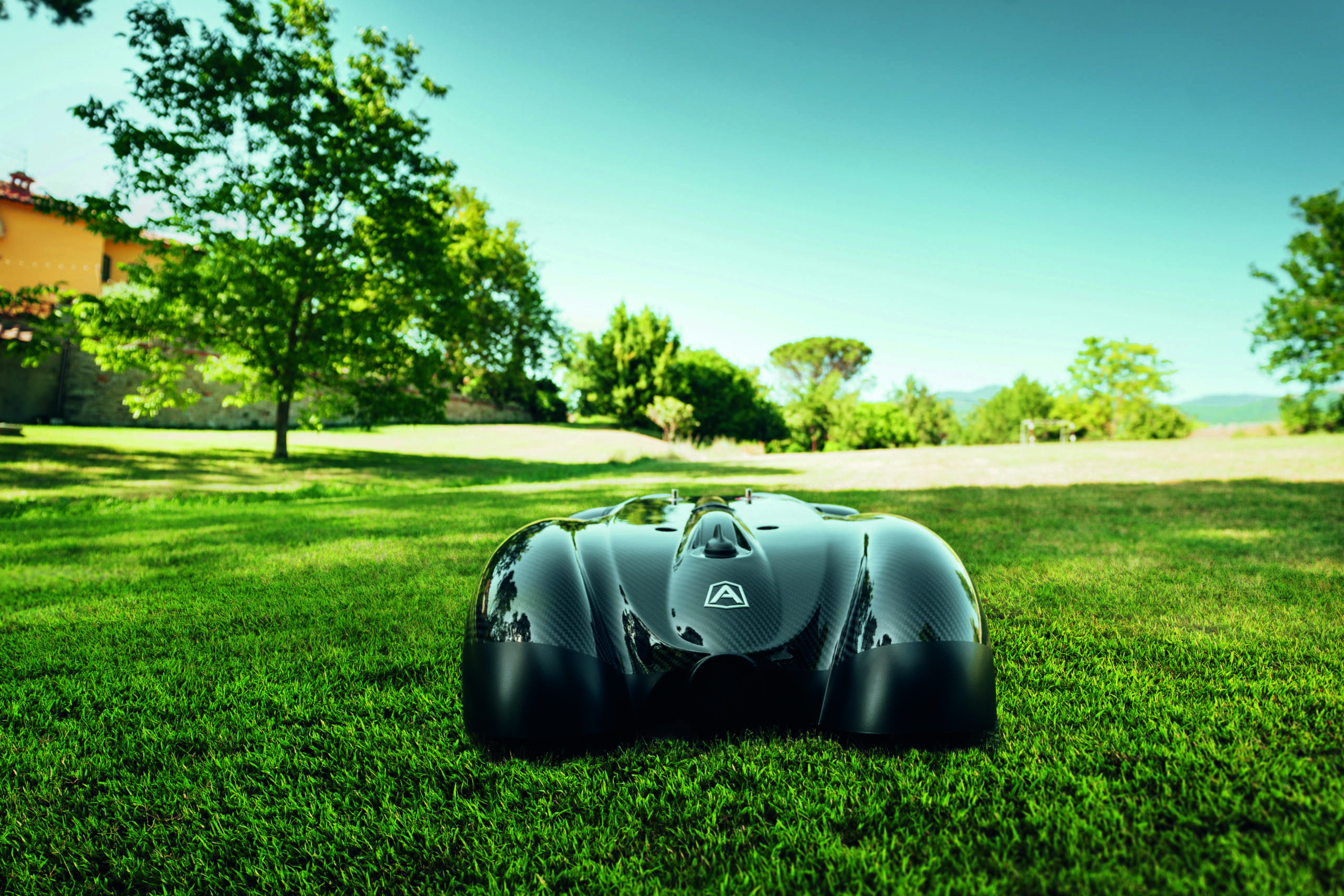 czarny automatyczny robot koszący na zielonej trawie